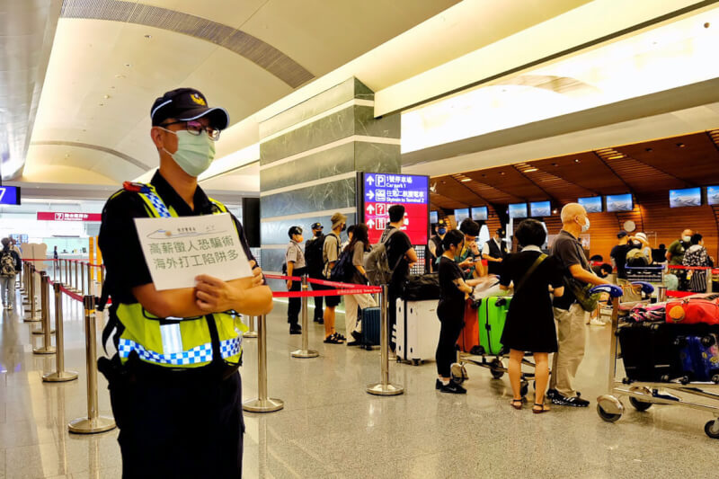 圖為警方在桃園國際機場舉牌提醒民眾慎防海外打工詐騙。（中央社檔案照片）