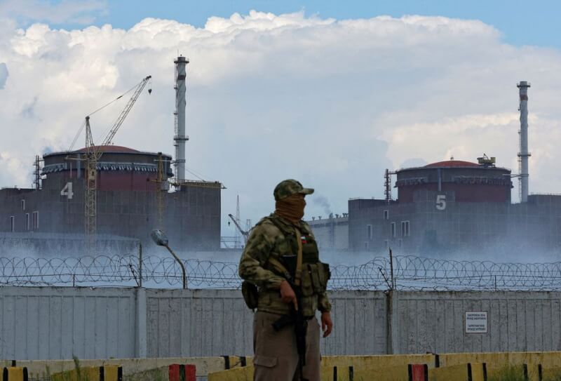 圖為一名制服上有俄羅斯國旗的軍人在札波羅熱核電站附近站崗。（路透社）