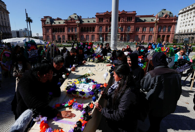 示威者19日在阿根廷總統府外圍繞著一口棺材，哀悼勞工的基本工資。（路透社）