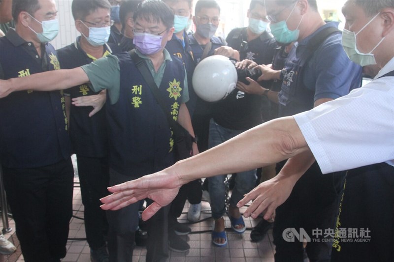 台南市2名警員22日執勤殉職,專案小組23日清晨在新竹市逮捕凶嫌林姓男子(戴白色安全帽者),上午帶回台南市第三警分局偵辦。中央社記者楊思瑞攝 111年8月23日