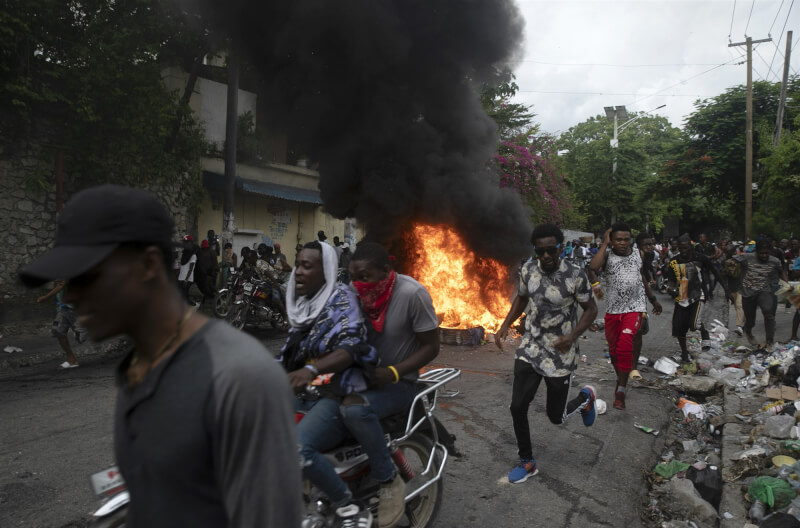 數以千計海地民眾在全國各地參與集會示威，抗議犯罪猖獗、消費者物價飆升。圖為22日民眾在首都太子港等部分地區設置燃燒的路障。（美聯社）