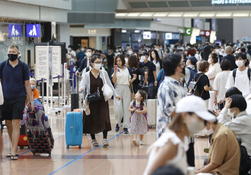日本政府考慮鬆綁邊境管制措施，將有條件取消入境者搭機前72小時內PCR陰性報告。圖為6日羽田機場人潮。（共同社）