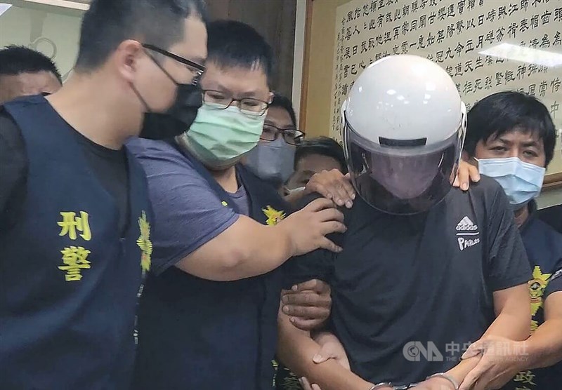 圖為台南殺警案凶嫌林信吾（白色安全帽者）23日落網，在警方訊後移送至台南地檢署。（中央社檔案照片）