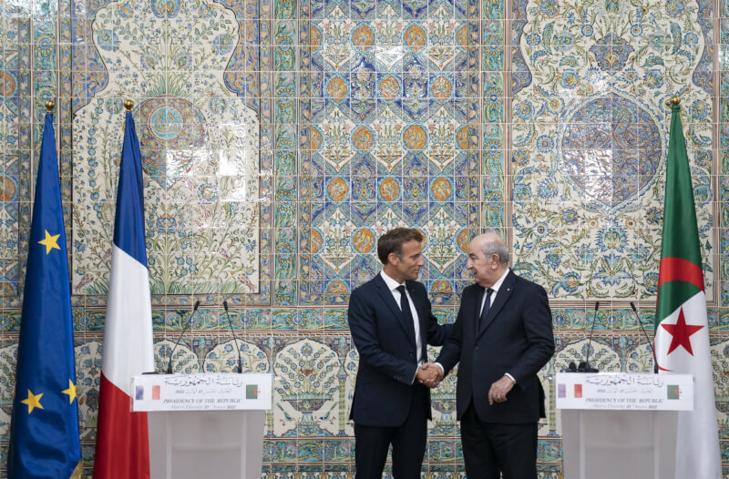 法國總統馬克宏（左）大陣仗訪團25日抵達阿爾及利亞，阿國總統塔布納（右）親自接機。（圖取自twitter.com/EmmanuelMacron）