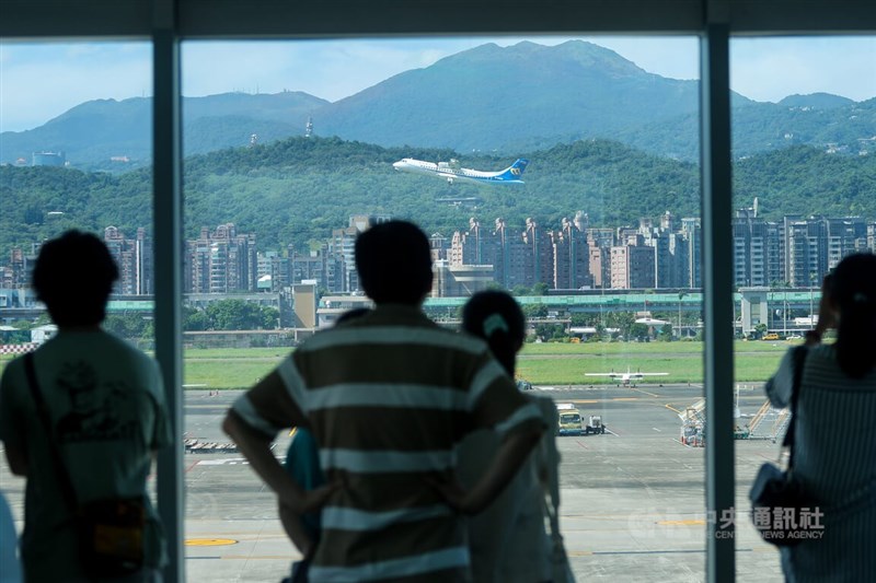 國內27日新增2萬5621例COVID-19本土病例。圖為民眾26日在松山機場觀景台看飛機起降。（中央社檔案照片）