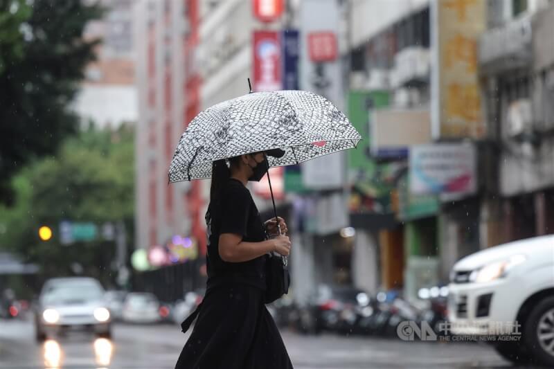 中央氣象局表示，27日晚上起受到北風影響，北部及東北部地區會有迎風降雨。圖為台北市中正區民眾撐傘過馬路。（中央社檔案照片）