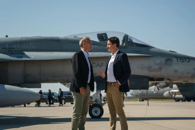 北大西洋公約組織秘書長史托騰柏格（左）26日在冷湖市的空軍基地與加拿大總理杜魯道（右）交談。（路透社）