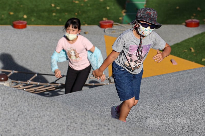 圖為台北市文山區一處公園午後有不少孩童戴好帽子、墨鏡、口罩兼顧防疫防曬，在豔陽下嬉戲。（中央社檔案照片）