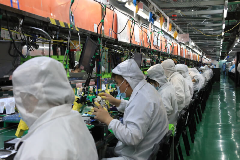 iPhone 14系列最大代工廠商富士康透露，部分生產線升級為Pro機型。圖為去年7月富士康鄭州科技園區裡工人工作情況。（中新社）