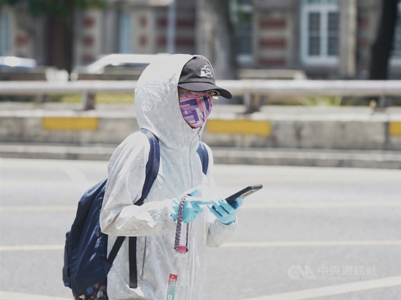 圖為走在台北市中正區的民眾全副武裝，配戴口罩全身包緊緊防疫。（中央社檔案照片）