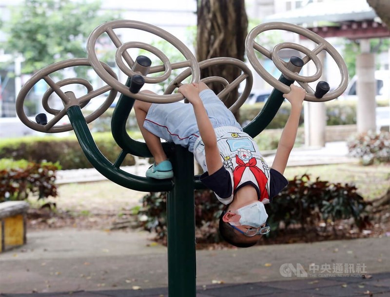 圖為小朋友在台北市南區一處公園遊憩，口罩不離身。（中央社檔案照片）