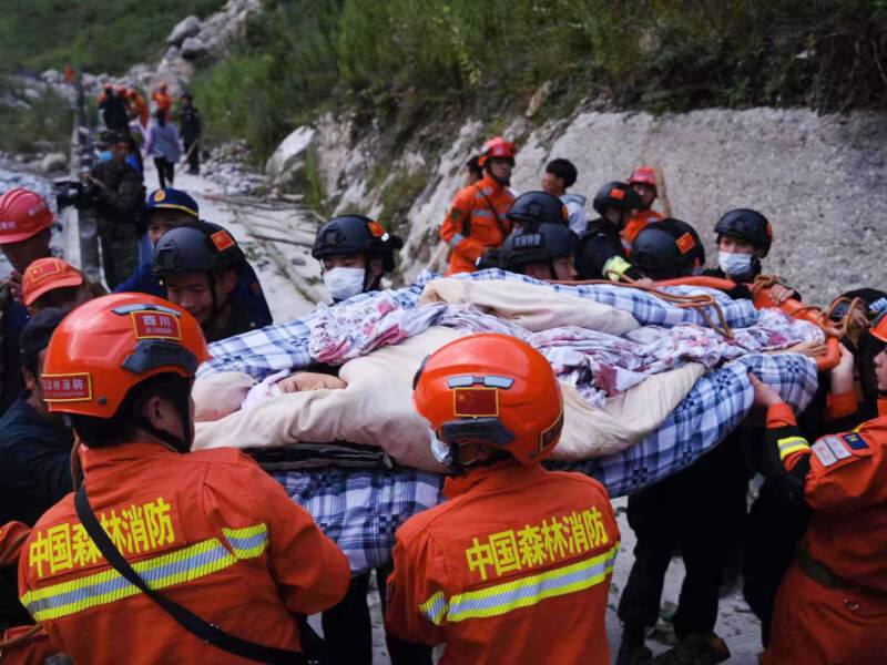 中國四川省瀘定縣5日發生規模6.8地震，官媒報導指出，目前至少有46人喪生、16人失蹤。圖為救援人員合力用擔架轉移傷員。（中新社）