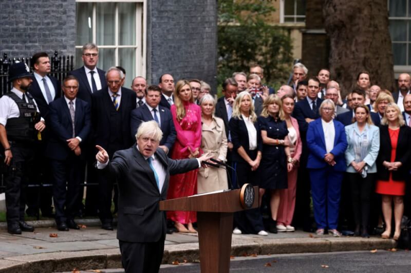 英國首相強生（前）6日在倫敦唐寧街官邸前發表卸任前的告別談話，將自己比喻成一節已完成任務的助推火箭。（路透社）