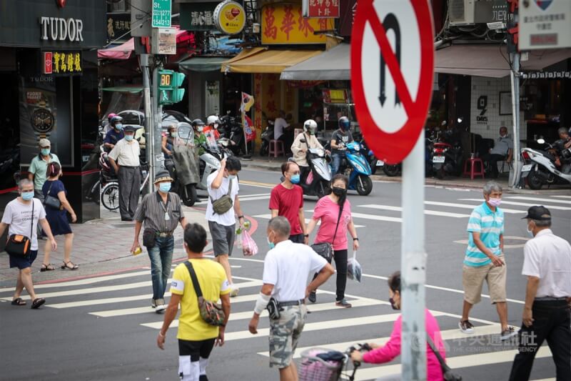 國內7日新增4萬1021例COVID-19（2019冠狀病毒疾病）本土病例。圖為台北市萬華區街頭，民眾外出配戴口罩。（中央社檔案照片）
