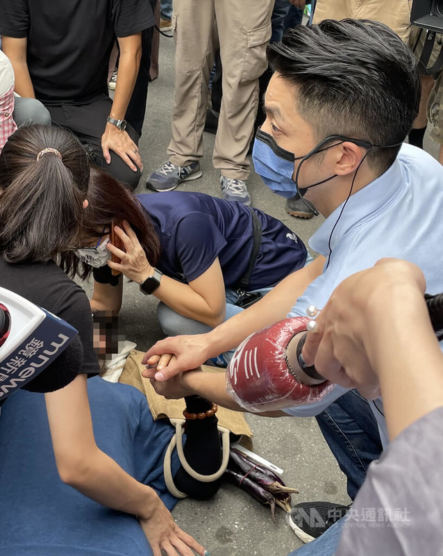 國民黨台北市長參選人蔣萬安（右）7日到白蘭巿場掃街拜票時，一名買菜婦人不明原因倒地，蔣萬安得知上前了解，握著婦人的手，不斷與婦人對話使她意識清楚。中央社記者劉世怡攝  111年9月7日