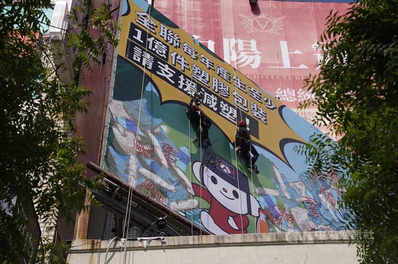 環保團體綠色和平8日在西門町街頭,以高空垂降的方式刊登廣告,公布全聯福利中心年產塑膠量,呼籲業者減塑。中央社記者徐肇昌攝 111年9月8日