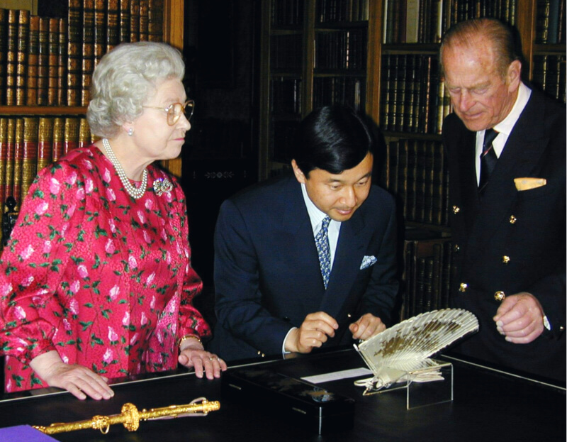 英國女王伊麗莎白二世辭世，日皇德仁9日表達深切哀悼。圖為英國女王（左）和菲利普親王（右）2001年在溫莎城堡向德仁（中）介紹紀念品。（共同社）