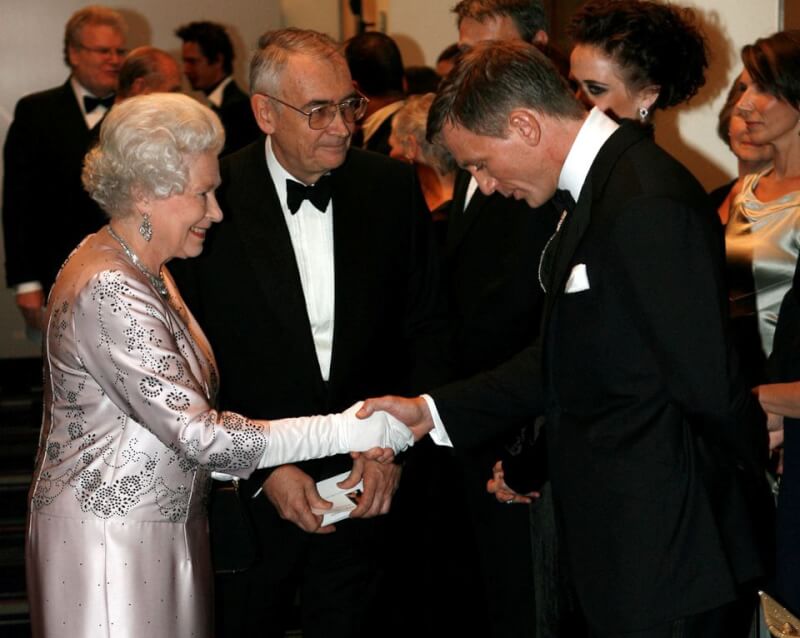 圖為飾演007情報員的丹尼爾克雷格（前右）在2006年11月電影007皇家夜總會首映活動會謁見英國女王伊麗莎白二世（前左）。（路透社）