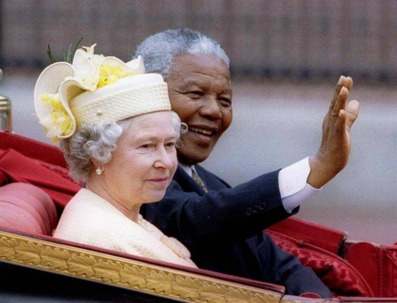 圖為1996年英國女王伊麗莎白二世（左起）與南非總統曼德拉於白金漢宮前乘坐馬車影像。（路透社）