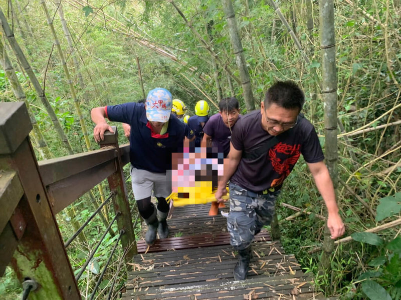 台南一名7旬婦人登嘉義縣梅山鄉青年嶺步道，11日中午不慎滑倒骨折，消防局獲報出動15名人員上山救援，將人從陡峭的步道抬出送醫。（嘉義縣消防局提供）中央社記者蔡智明傳真  111年9月11日