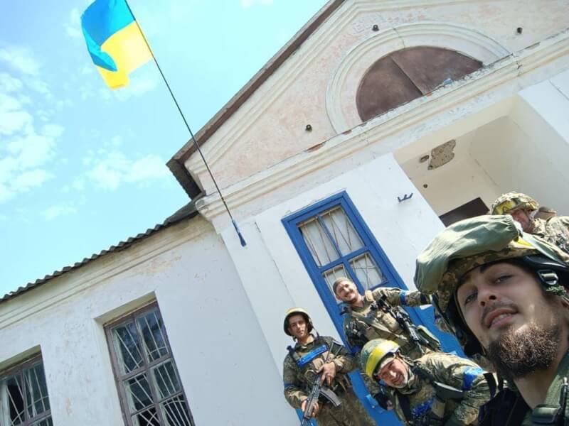 圖為烏軍收復哈爾科夫失土，在一處建物旁微笑合影。（圖取自facebook.com/TerritorialDefenseForces）