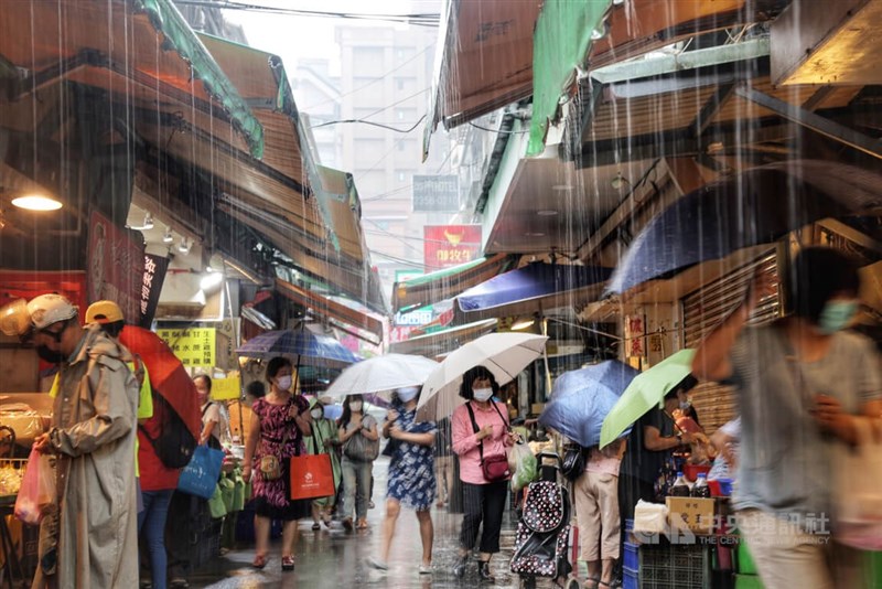 圖為民眾撐傘到台北市中正區東門市場採買。中央社記者王飛華攝 111年9月11日