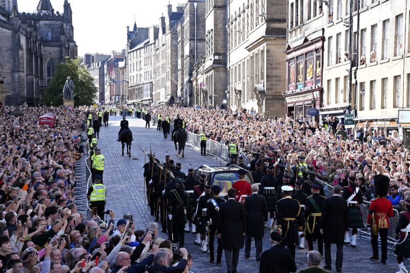 英國女王伊麗莎白二世女王靈柩12日沿著蘇格蘭首府愛丁堡的「皇家大道」莊嚴肅穆地遊行前往聖吉爾斯大教堂，大批民眾聚集路旁送行。（美聯社）