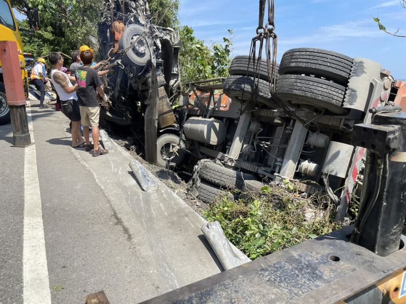 一輛聯結車15日行經台2線宜蘭頭城段時衝出路邊護欄後側翻，卡在下邊坡處，距離下方的鐵軌只有10公尺，當地鐵公路一度封閉。（台鐵提供）中央社記者沈如峰宜蘭縣傳真  111年9月15日