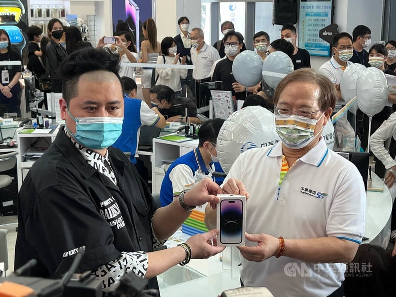 中華電信16日在台北東區服務中心舉辦iPhone 14新機首賣會，董事長謝繼茂（右）為首位排隊客戶許先生（左）加碼送出Hami Point 6600點。中央社記者吳家豪攝 111年9月16日
