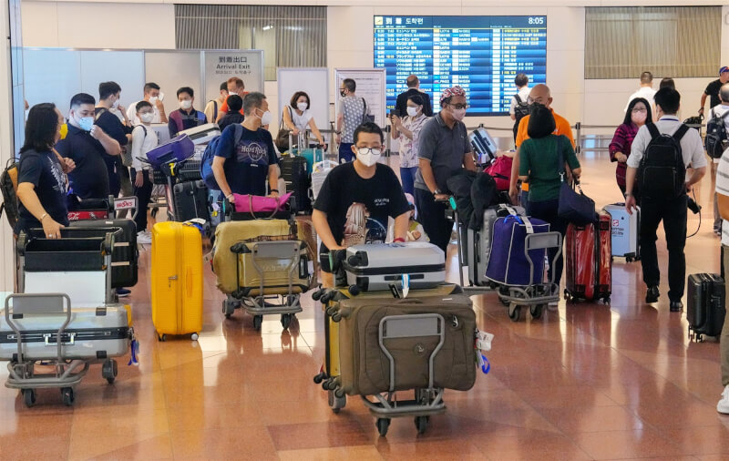 日本有意修法，讓業者在疫情期間可拒絕不戴口罩的旅客投宿。圖為7日抵達東京羽田機場的外國旅客。（共同社）