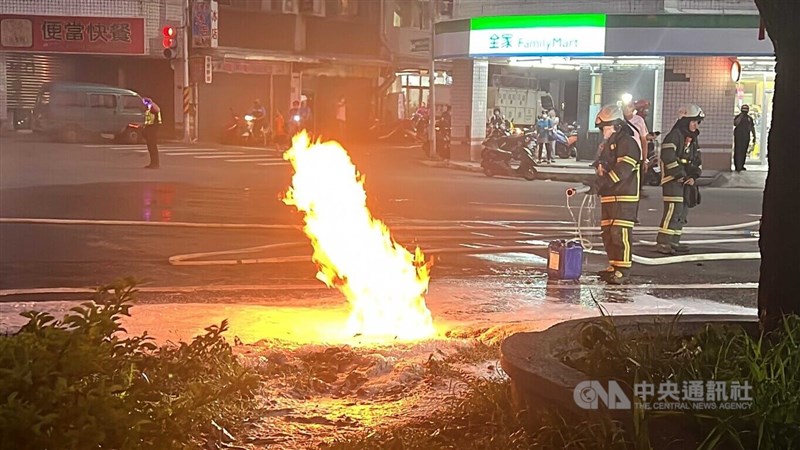 台東市中興路台糖加油站19日晚間油槽漏油流入水溝，引起多處水溝蓋竄出1樓高火焰，警消人員戒備、滅火，所幸台糖及時關閉漏油槽，火勢得以控制。中央社記者盧太城台東攝 111年9月19日