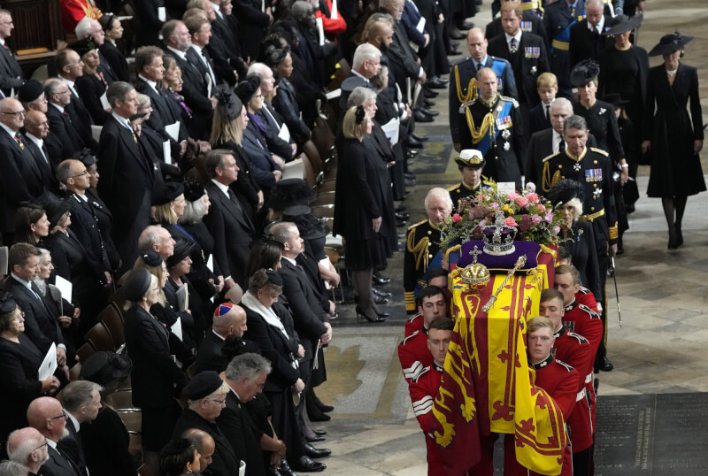 英國女王國葬儀式結束，士兵抬著靈柩準備移至砲架車，查爾斯三世、王后卡蜜拉等英國王室成員在靈柩後方跟隨。（Frank Augstein/Pool Photo via 美聯社）