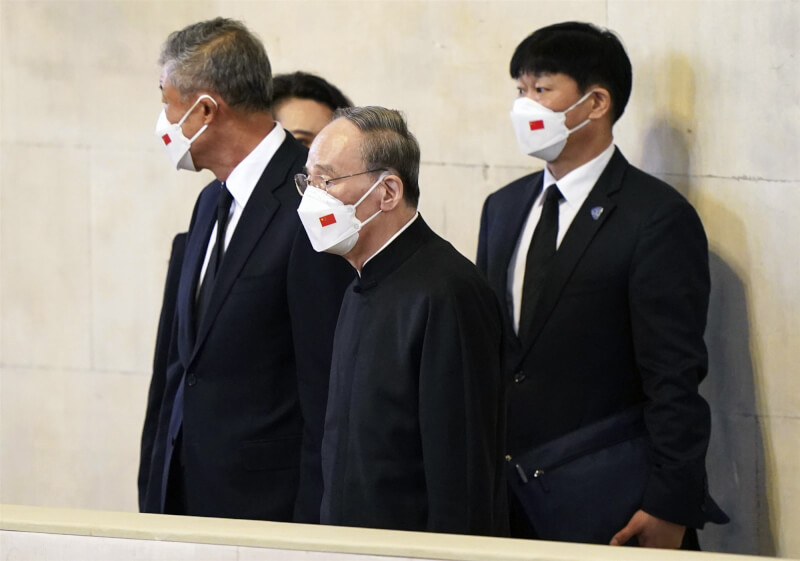中國國家副主席王岐山（中）19日出席英國女王國葬，各國政要中只有中國代表全程戴口罩參加，引發網友熱議。（美聯社）