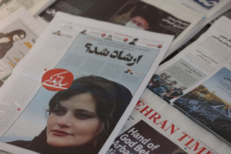 伊朗22歲女子艾米尼因違反服裝儀容規定遭「宗教警察」逮捕，卻在昏迷3天後喪命，引發公憤。圖為伊朗報紙頭版印有艾米尼照片。（Majid Asgaripour/WANA (West Asia News Agency) via 路透社）