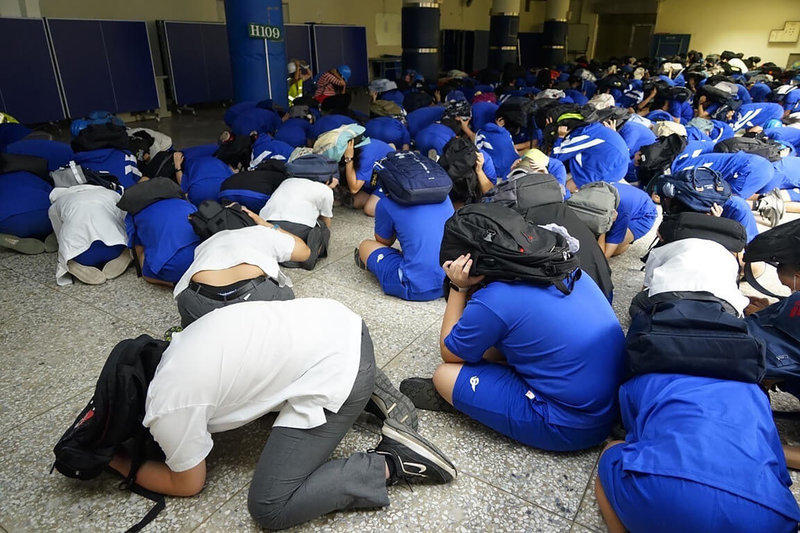 台北市各級學校21日上午進行國家防災日防空地震複合式災害疏散避難演練，大直高中學生落實防空避難姿勢。（台北市政府提供）中央社記者陳昱婷傳真  111年9月21日