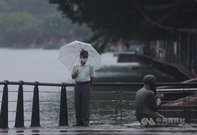 中央氣象局表示，24日東北風增強，北部及東北部應防局部大雨。圖為民眾在淡水撐傘擋雨。（中央社檔案照片）