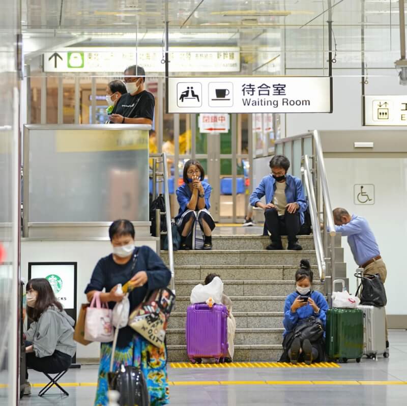 颱風塔拉斯侵襲日本，造成往來東京與大阪的東海道新幹線停駛。圖為24日民眾在東京站內等待。（共同社）