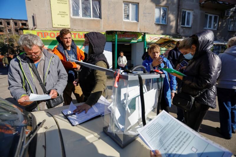 俄羅斯掌控下的烏克蘭頓內茨克州等4大地區正在舉辦入俄公投，頓內茨克州城市馬立波民眾25日在一處移動投票箱投票。（路透社）
