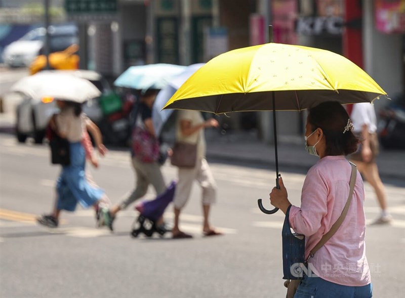 氣象專家吳德榮表示，27日白天偏熱，高溫可達攝氏35、36度，為秋老虎的天氣型態。圖為台北市內湖區街頭民眾撐傘遮陽防曬。（中央社檔案照片）
