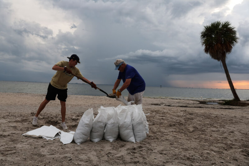 美國佛羅里達民眾正在製作沙袋，防範颶風伊恩可能帶來的強風與洪災。（路透社）