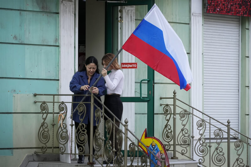 在由俄羅斯主導的公投結束後，烏克蘭東部盧甘斯克地區的居民28日在自家門前懸掛俄國國旗。（美聯社）