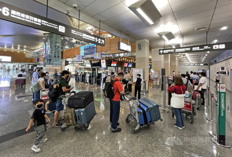 圖為台北松山機場旅客排隊辦理出境手續。（中央社檔案照片）