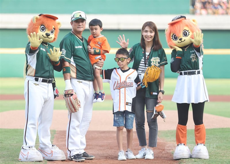 中職統一獅隊41歲野手潘武雄1日在台南棒球場舉行引退賽，潘武雄（左）與大小兒子一同完成開球儀式，並與太太一起在場中留下全家福合影。中央社記者張新偉攝 111年10月1日