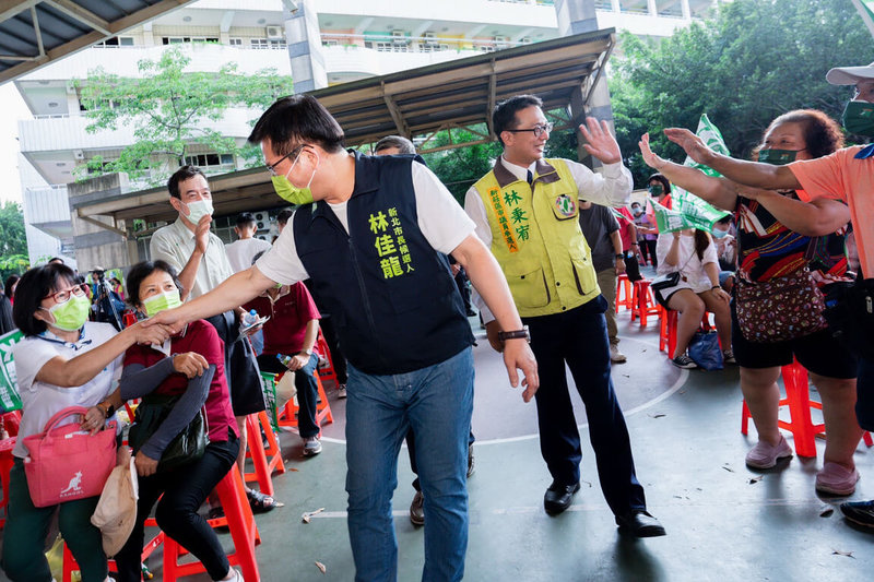 民進黨新北市長參選人林佳龍（中左）1日到新莊區參加與同黨市議員參選人林秉宥（中右）的聯合競選總部成立大會，兩人親切與選民握手互動。（林佳龍競選辦公室提供）中央社記者黃旭昇新北市傳真  111年10月1日