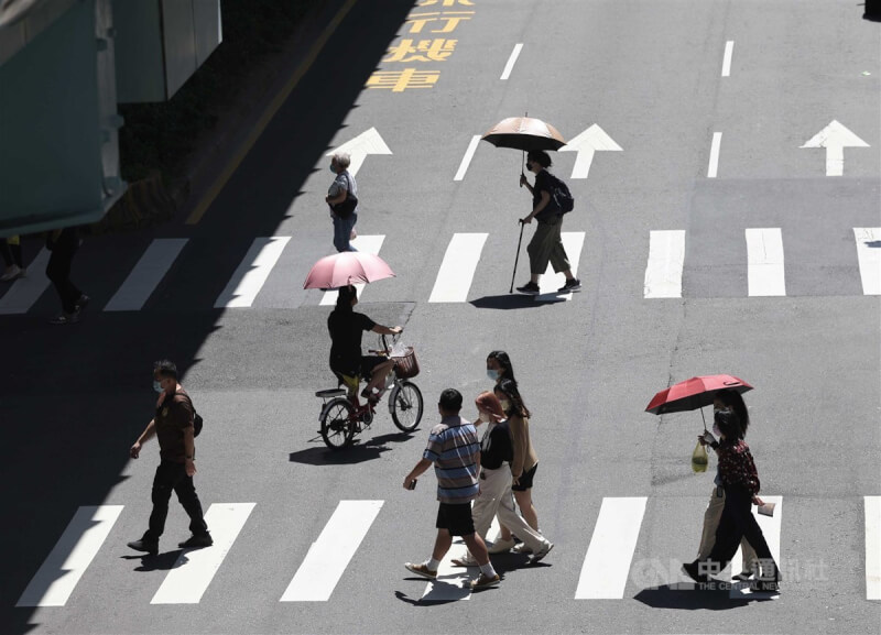 圖為台北市大安區民眾撐傘過馬路。（中央社檔案照片）