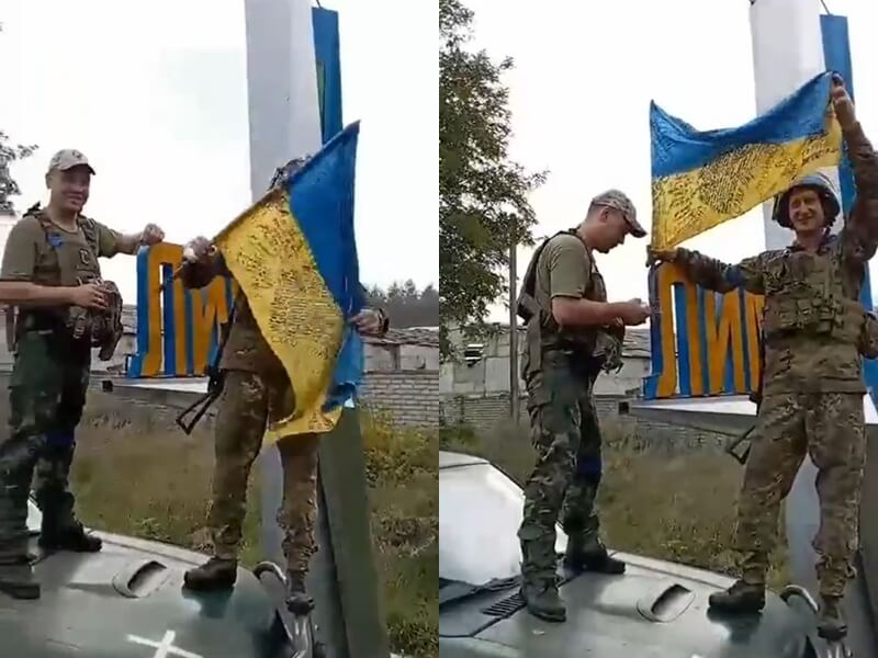 圖為烏克蘭士兵在寫有利曼鎮名稱的標誌旁舉起烏克蘭國旗。（圖取自twitter.com/DefenceU）