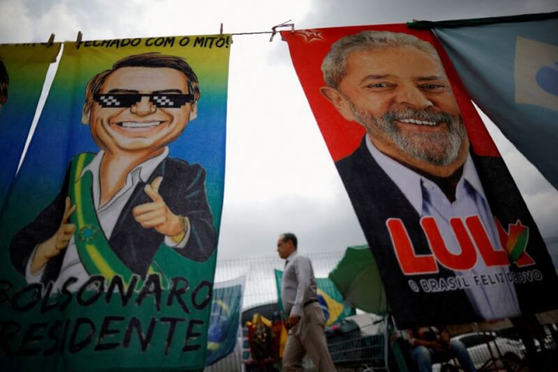 巴西總統大選10月底將舉行第2輪投票，競選中出現善惡二分言詞，以極端語言醜化對手。圖為9月23日巴西民眾經過波索納洛肖像畫及魯拉的競選布條。（路透社）