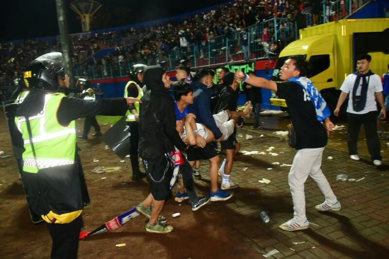 印尼東爪哇省瑪琅市足球賽踩踏事件造成125人死亡、323人受傷。圖為民眾合力抬走傷患。（路透社）