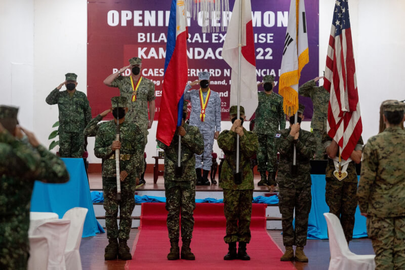 美國、菲律賓、日本及韓國陸戰隊員手持國旗參加「海上戰士合作」演習開訓典禮。（路透社）