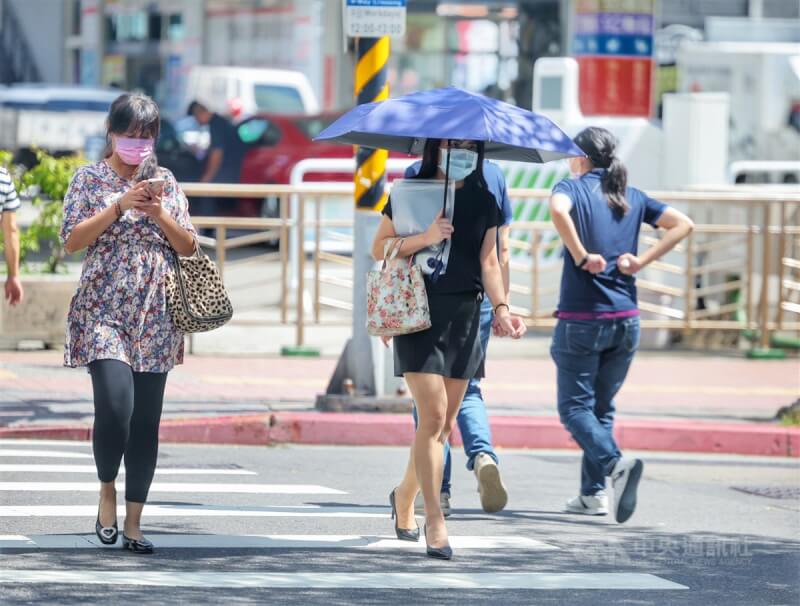 圖為3日台北街頭民眾撐傘遮陽。中央社記者王飛華攝 111年10月3日